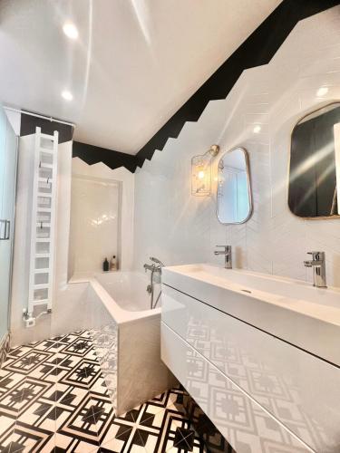 une salle de bain avec une baignoire blanche et un lavabo dans l'établissement Appartement cosy à Paris 130 m² avec projecteur !, à Paris