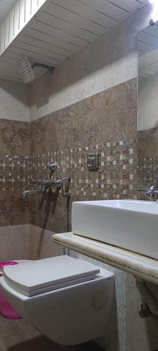 a bathroom with a toilet and a sink and a tub at Hotel Golden Park Near NESCO in Mumbai