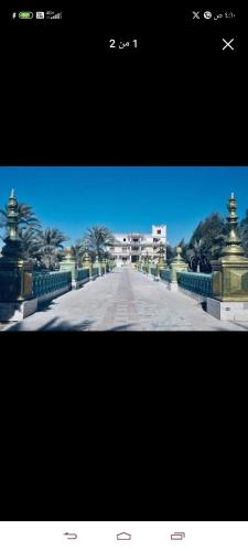 a picture of a road with palm trees and an airplane at Booking home stay in 6th Of October