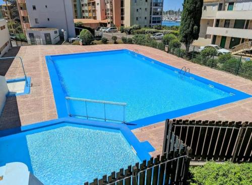 une grande piscine avec de l'eau bleue dans un immeuble dans l'établissement Cap d'Agde - Studio lumineux 2 - 4 personnes Terrasse avec vue, au Cap d'Agde