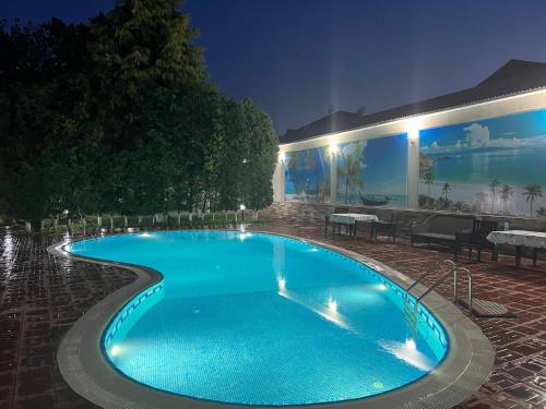 a large swimming pool in a resort at night at VIARDO Hotel in Tashkent