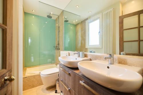 a bathroom with two sinks and a toilet at The Peckham Hideaway - Bright 3BDR Flat in London