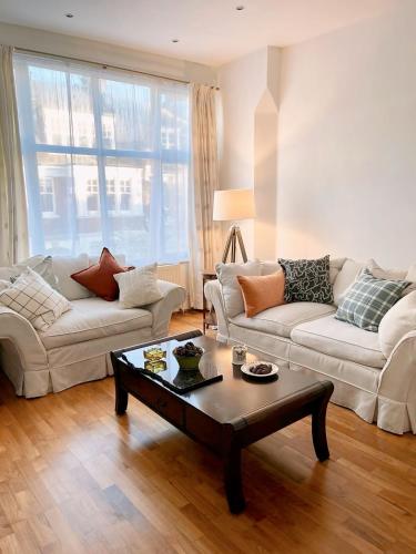 a living room with two couches and a coffee table at Spacious Belsize Park apartment close to station in London