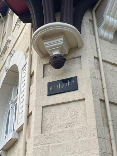 un bâtiment avec un panneau indiquant la rue sur son côté dans l'établissement Le paddock deauvillais, à Deauville