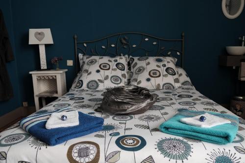 a bed with towels and pillows on it at Pause Campagne - Chambres d'Hôtes in Pouy-de-Touges