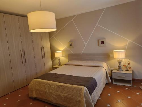 - une chambre avec un grand lit et deux lampes dans l'établissement La casetta del poggio, à Poggio a Caiano