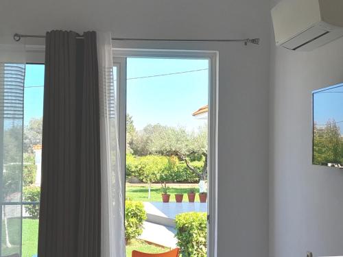 a sliding glass door with a view of a yard at Villa Maroula in Afantou
