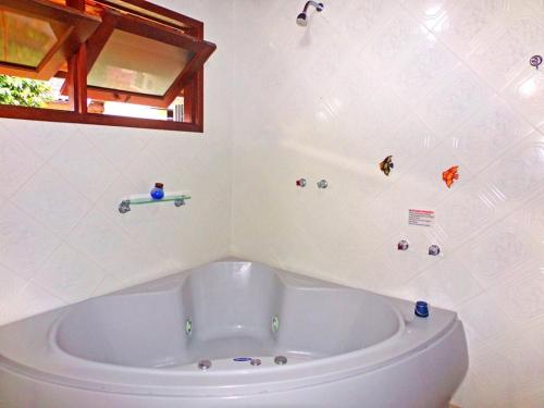 a bathroom with a bath tub in a room at Hotel Cantinho de Férias in Visconde De Maua