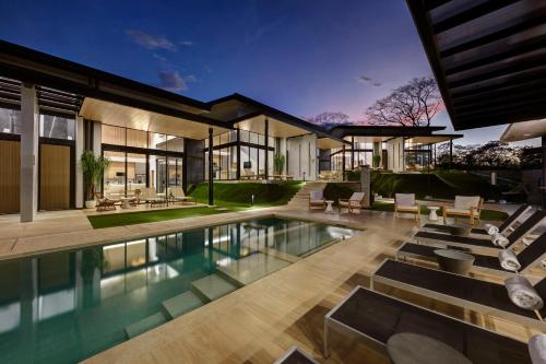 an exterior view of a house with a swimming pool at Epic Tamarindo Boutique Hotel in Tamarindo