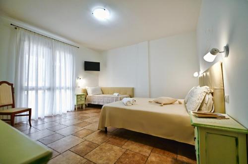 - une chambre avec un lit et un canapé dans l'établissement Olimpo B&B, à Giurdignano