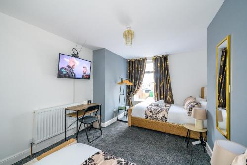 1 dormitorio con 1 cama, escritorio y TV en *RB31S* For your relaxed & Cosy stay/Parking/WiFi, en Morley