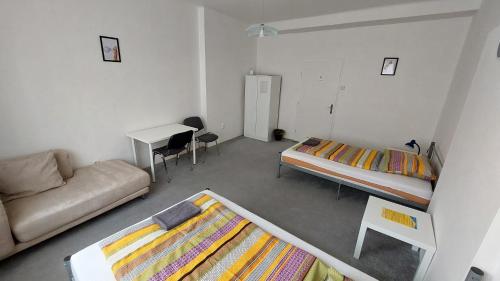 a room with two beds and a couch and a desk at Bonvolon in Prague