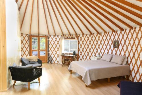 1 habitación con 1 cama y 1 silla en una yurta en neversink river resort, 