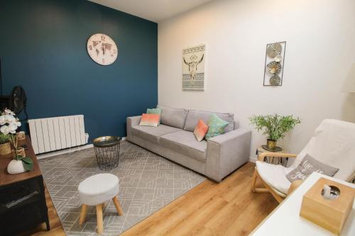 a living room with a couch and a clock on the wall at Residence Pasteur Angouleme in Angoulême