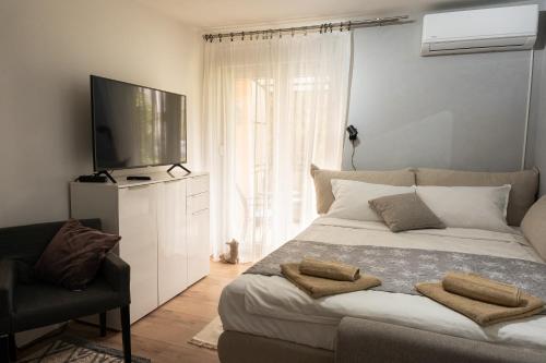 Apartment City Cat في Križevci: غرفة نوم بسرير كبير وتلفزيون بشاشة مسطحة