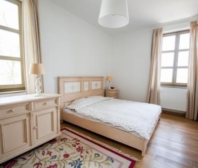 a bedroom with a bed and a dresser and windows at Villa Portico in Badacsonytomaj