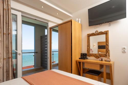 a bedroom with a mirror and a television at Megkas Theodoros in Paralia Katerinis