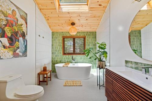 a bathroom with a tub and a toilet and a sink at The Green Forest Retreat - Kayak, Hot Tub, Sauna in East Stroudsburg