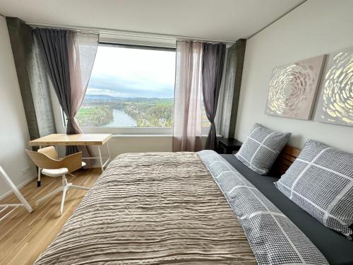 1 dormitorio con 1 cama grande y ventana grande en 2.5 Room@MydiHei Apartments en Neuhausen am Rheinfall