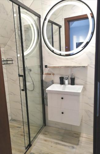 a bathroom with a sink and a mirror at Apartamenty WIKTORIA morska18 in Kuźnica