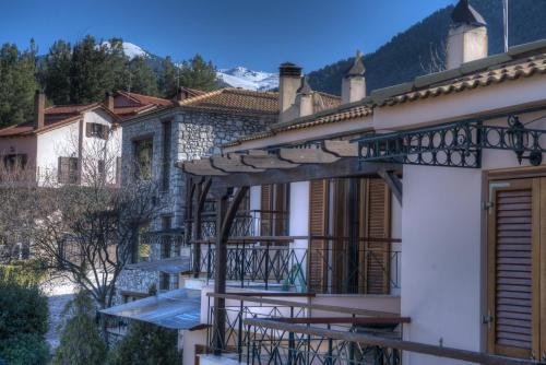 a house with a balcony with a mountain in the background at Finday Eco Boutique Hotel in Kalavrita