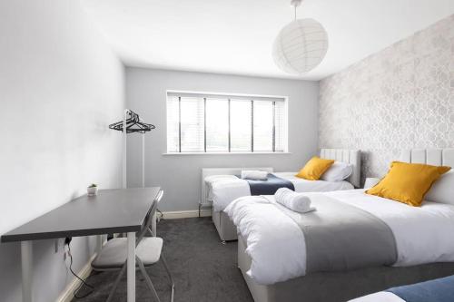 1 dormitorio con 2 camas y escritorio. en Large Contractor House/ Fits 10/ Free Parking/Discount Long Term Stays en Leeds