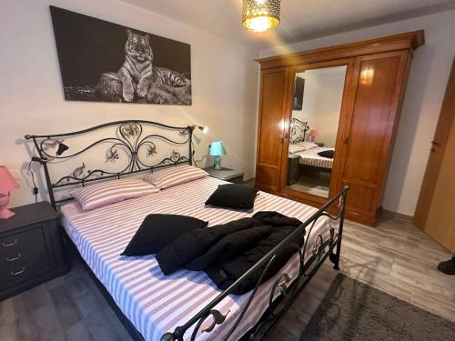 1 dormitorio con 1 cama en blanco y negro con espejo en Casa Relax Immersa Nel Verde, en Manzano