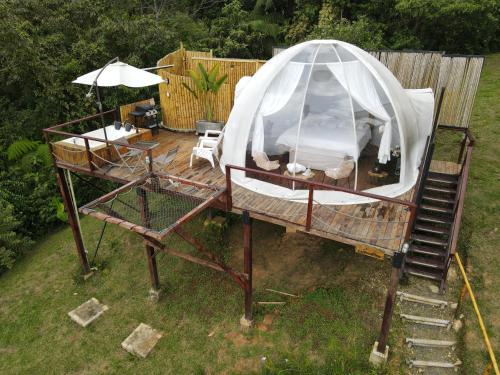 a canopy bed on a deck with an umbrella at MACA GLAMPING in Calima
