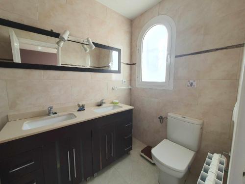 a bathroom with a toilet and a sink and a mirror at Costa Brava Suites Villa Cèsar in Calonge