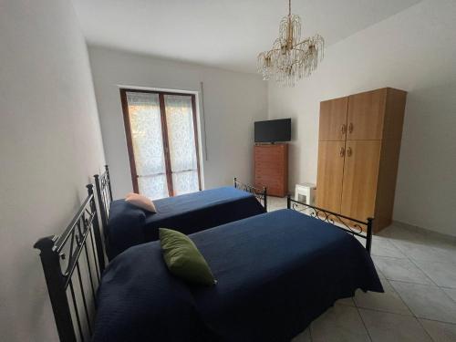 1 dormitorio con 2 camas, armario y lámpara de araña en Jeranto Apartment, en Piano di Sorrento