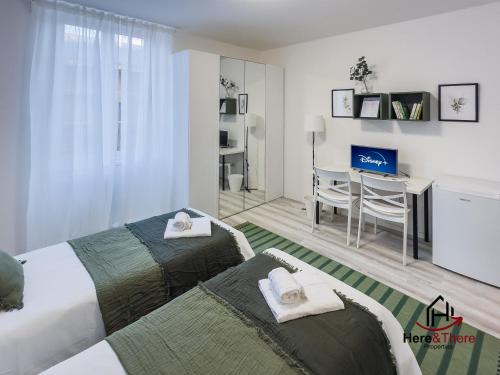a bedroom with two beds and a desk in it at [Comfort Suite] Airport 5min • A/C • Disney+ in Genoa