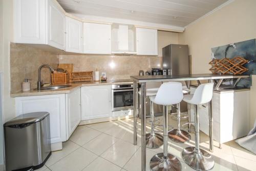 a kitchen with white cabinets and stainless steel appliances at T3 Somptuosa 1 ère ligne Vue Mer Palavas in Palavas-les-Flots