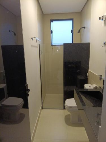 a bathroom with a shower and a toilet and a sink at Residencial ponta do sol in Capitólio