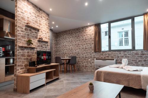 a bedroom with a brick wall and a bed and a table at Parthenon Portrait Apartments in Athens