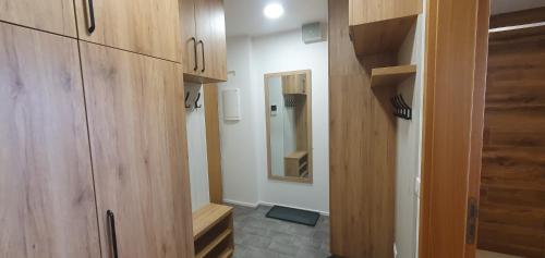 a small bathroom with wooden cabinets and a mirror at Ski&Bike Apartment Janské Lázně + Parking in Janske Lazne
