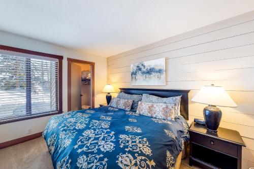 um quarto com uma cama azul e uma janela em Snowcreek 1536 em Sun Valley