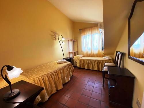 ランダッツォにあるAi Tre Parchi Bed And Bikeのベッド2台とテーブルが備わるホテルルームです。