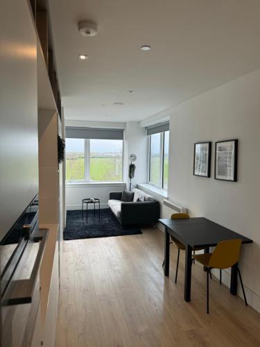 a living room with a table and a couch at LUXX Apartment & Suites, London Heathrow Airport, Terminal 4, Piccadilly underground Train station nearby! in New Bedfont