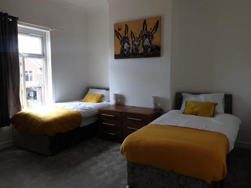 a bedroom with two beds and a window at Lenny House in Bradshaw