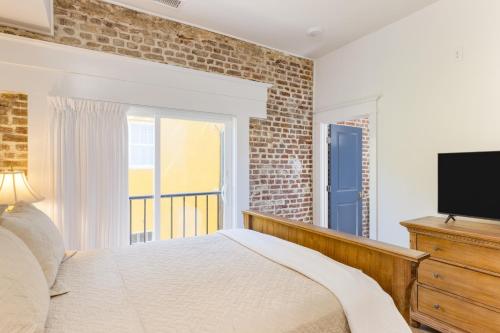 1 dormitorio con 1 cama y TV de pantalla plana en State St A by AvantStay Heart of French Quarter, en Charleston