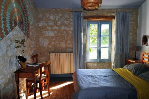 - une chambre avec un lit, un bureau et une fenêtre dans l'établissement La Chambre des Marronniers, à La Romieu