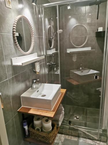 a bathroom with a sink and two mirrors at Austrumi in Kolka