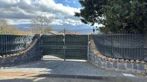 een poort op een stenen weg met een hek bij Soggiorno contrada difesa in Maletto
