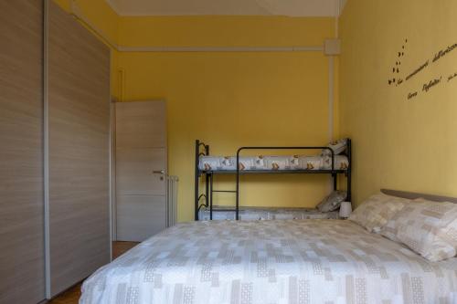 1 dormitorio con cama y pared amarilla en La Villetta a Cuneo, en Cuneo
