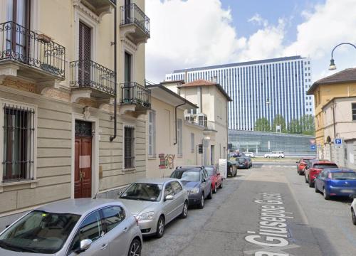 Margarita Apartment Porta Susa Torino في تورينو: صف من السيارات تقف على جانب شارع