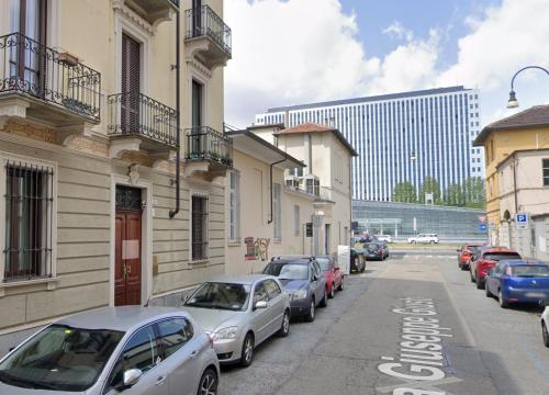 a row of cars parked on the side of a street at Margarita Apartment Stazione Porta Susa Torino in Turin