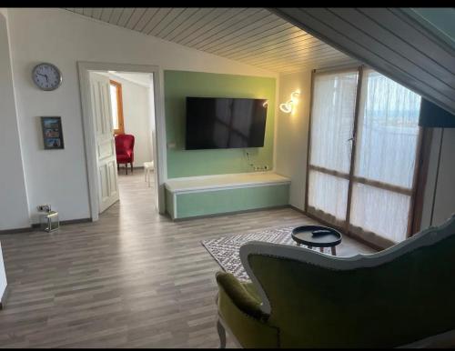 a living room with a flat screen tv and a couch at B&B Villa Alma in San Costanzo