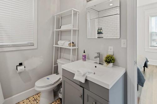 a white bathroom with a sink and a toilet at Modern 4BR 2BA Apt Steps to the Beach Open Living in Atlantic City