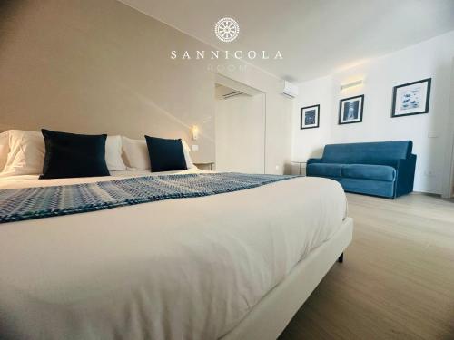 a bedroom with a large bed and a blue couch at San Nicola Room e spa in Gravina in Puglia