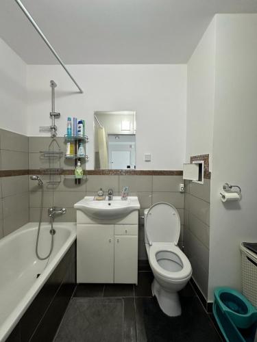 een badkamer met een toilet, een wastafel en een bad bij Przytulne mieszkanie blisko kanalu in Giżycko